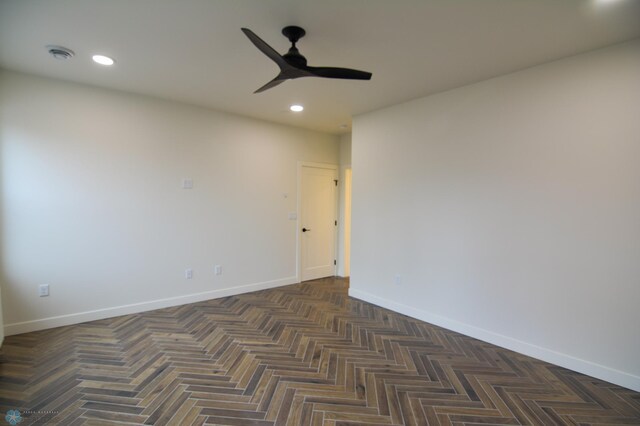 empty room with ceiling fan and dark parquet floors