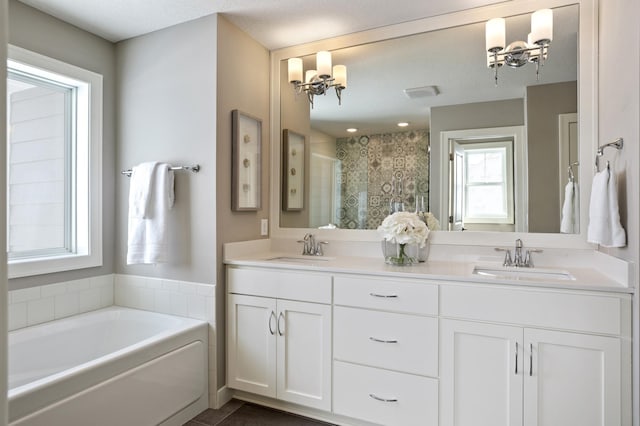 bathroom with tile patterned flooring, double sink vanity, a chandelier, a textured ceiling, and separate shower and tub