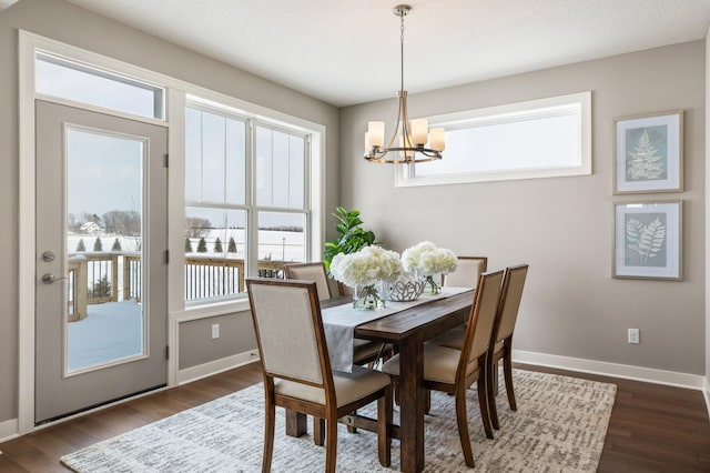 dining space featuring dark hardwood / wood-style floors, a notable chandelier, and a wealth of natural light