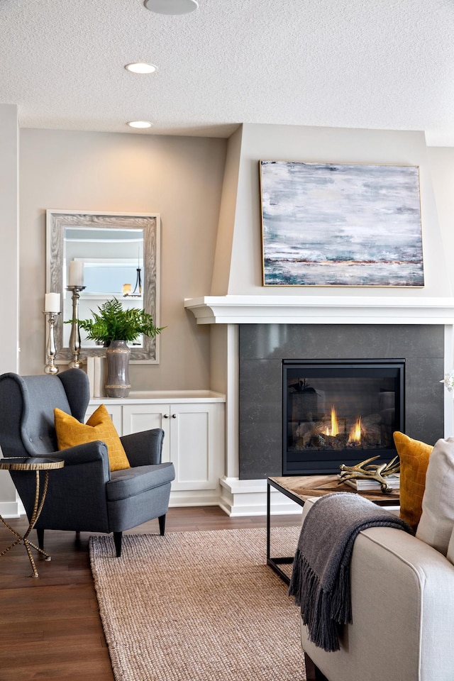 living room with a textured ceiling and wood-type flooring