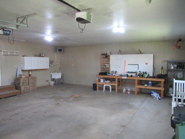 garage with a workshop area, sink, and a garage door opener