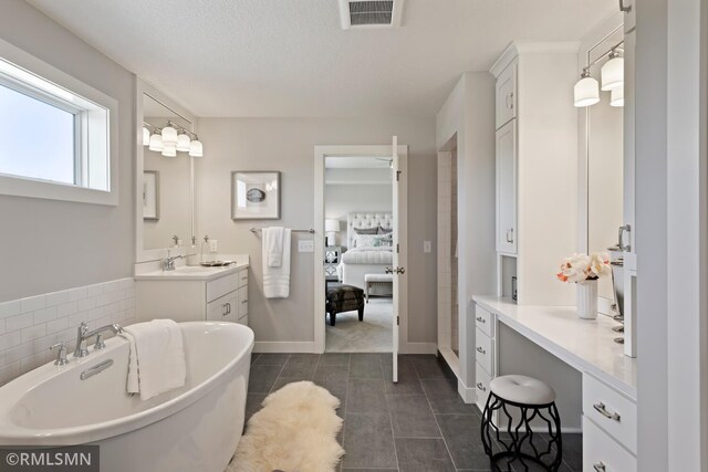 6528 Timber Arch Dr, Chaska, MN 55318 - ensuite bathroom with vanity, ensuite bath, visible vents, tile patterned floors, and a freestanding bath