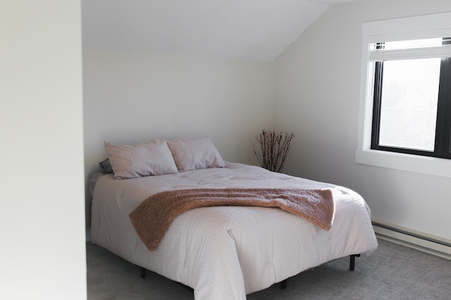 bedroom with a baseboard heating unit, vaulted ceiling, and carpet