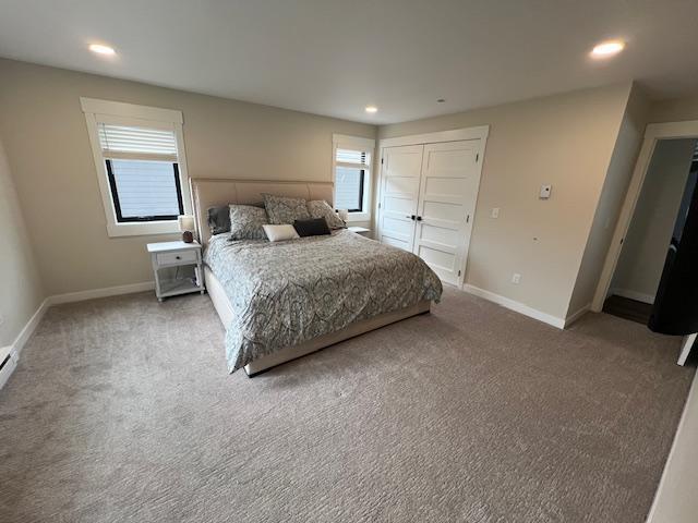 bedroom with a closet, recessed lighting, baseboards, and carpet