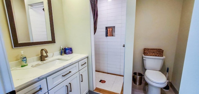 full bath with vanity, toilet, and tiled shower