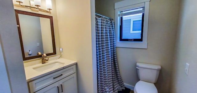 bathroom featuring vanity, curtained shower, and toilet