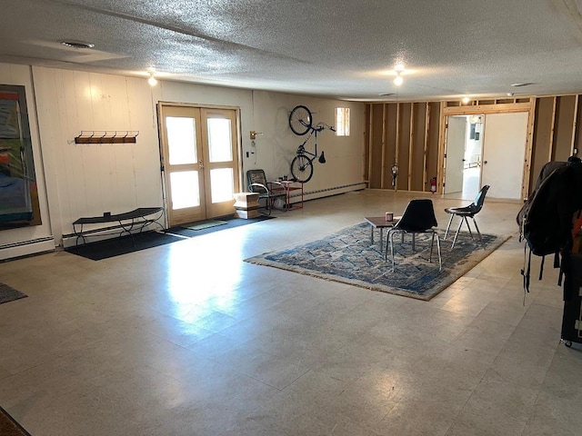 living room featuring baseboard heating, french doors, and a textured ceiling