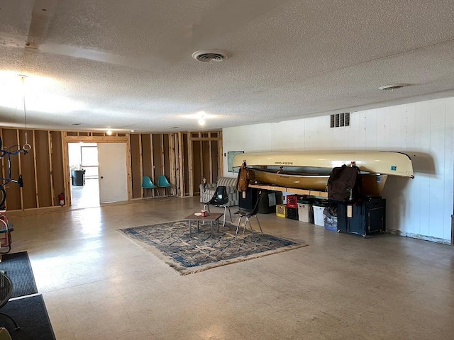 basement featuring wood walls and a textured ceiling