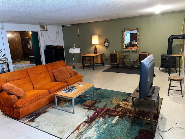 living room featuring a wood stove and a textured ceiling