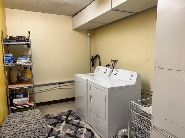 clothes washing area with a textured ceiling and separate washer and dryer