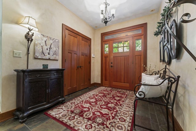 foyer featuring baseboards and a notable chandelier