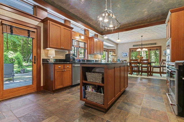 kitchen featuring dark countertops, an inviting chandelier, stone tile flooring, and appliances with stainless steel finishes