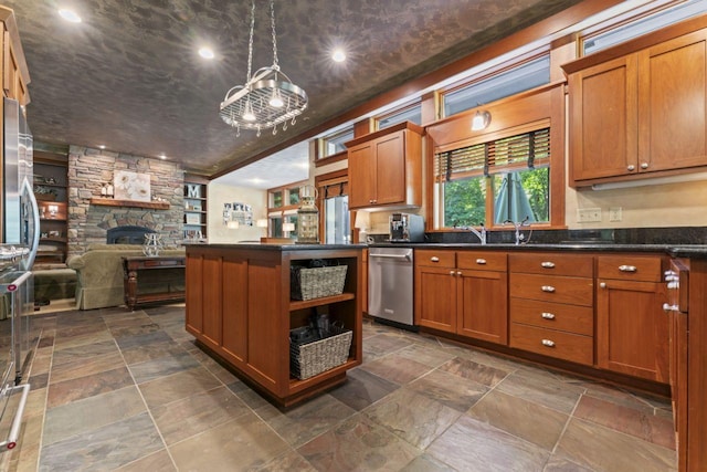 kitchen featuring a fireplace, sink, pendant lighting, a notable chandelier, and dishwasher