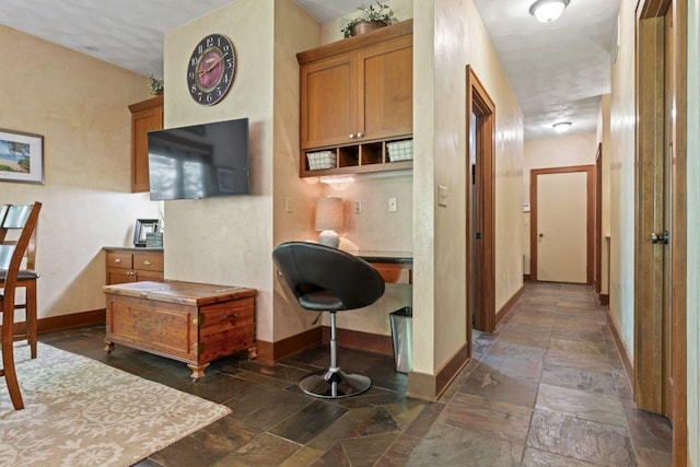 interior space featuring stone tile floors and baseboards