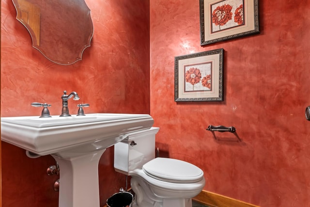 bathroom with toilet and baseboards