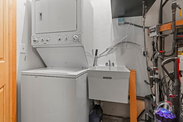 laundry room with a sink, stacked washer / dryer, and laundry area