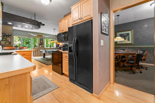 kitchen with black appliances, sink, hanging light fixtures, light hardwood / wood-style flooring, and light brown cabinetry