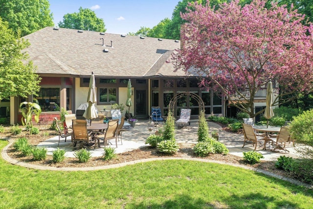 back of house featuring a patio area and a lawn