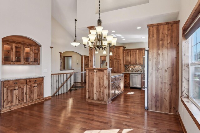 kitchen with a chandelier, dark hardwood / wood-style floors, tasteful backsplash, dishwasher, and hanging light fixtures