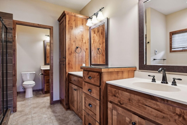 bathroom featuring baseboards, vanity, toilet, and tile patterned floors