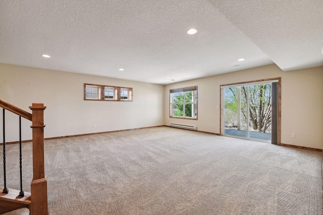 interior space with light carpet, baseboard heating, stairs, and baseboards