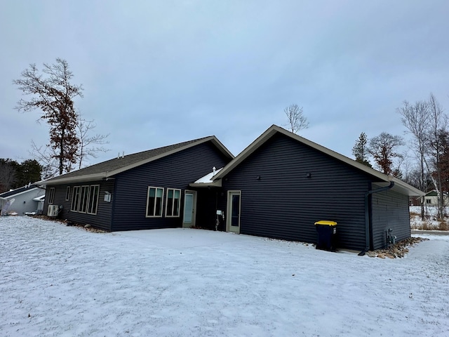 view of snow covered back of property