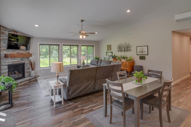 dining space with a fireplace, hardwood / wood-style floors, ceiling fan, and lofted ceiling