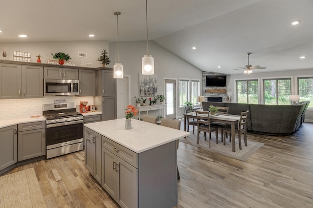 kitchen with pendant lighting, gray cabinetry, light wood-type flooring, and stainless steel appliances