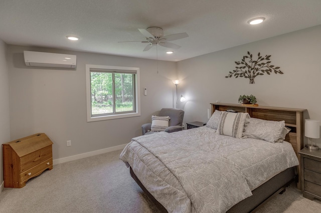 carpeted bedroom featuring a wall unit AC and ceiling fan