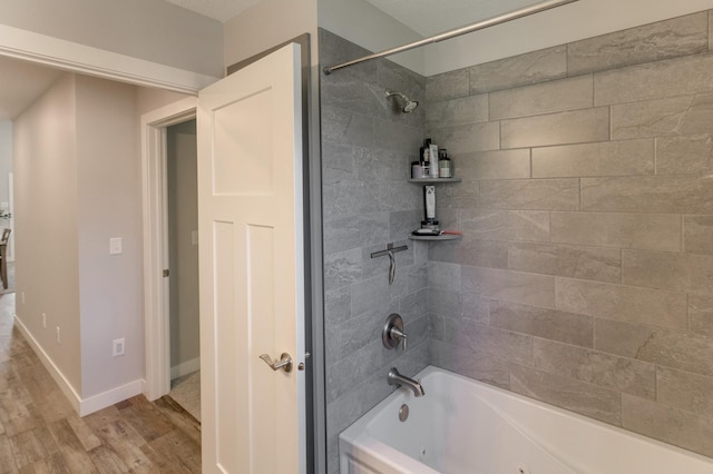 bathroom featuring hardwood / wood-style floors and tiled shower / bath combo