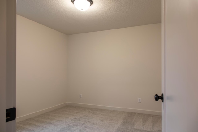 carpeted empty room with a textured ceiling