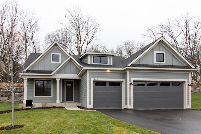 view of front facade with board and batten siding, a front lawn, and aphalt driveway