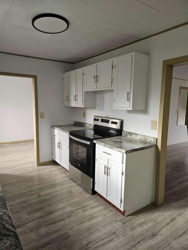 kitchen featuring white cabinetry, stainless steel range with electric stovetop, and light wood-type flooring