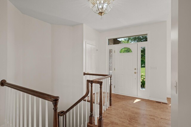 entrance foyer with a notable chandelier and light hardwood / wood-style flooring