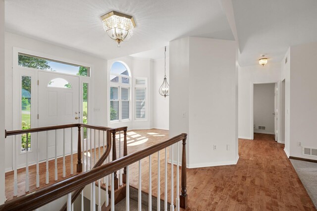 entryway featuring a notable chandelier and carpet