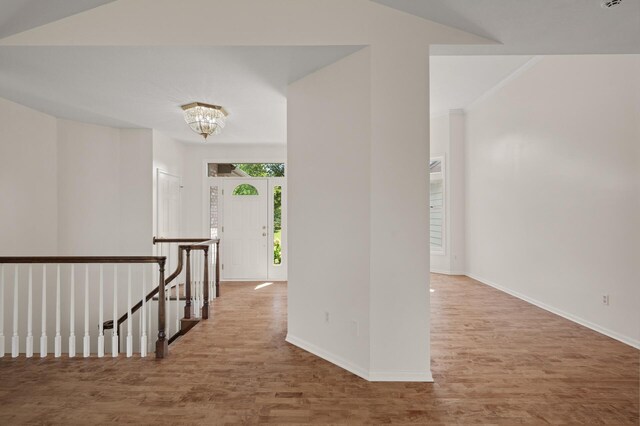 hallway with hardwood / wood-style flooring and a chandelier