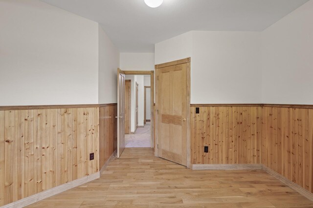 hall featuring wood walls and light hardwood / wood-style flooring