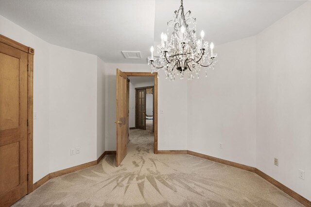 carpeted empty room with a chandelier