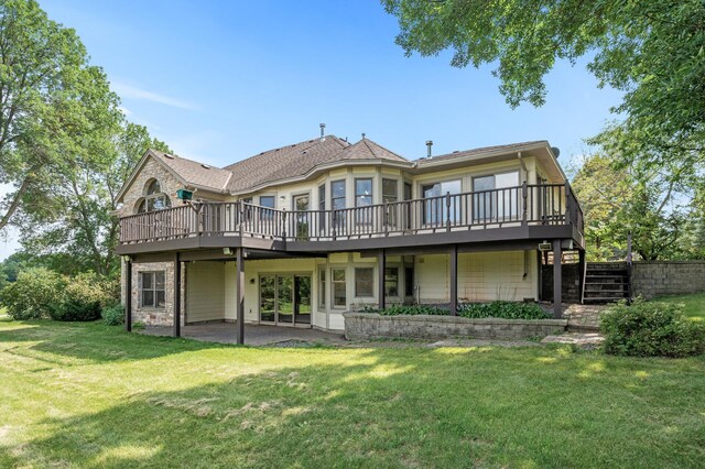 rear view of house featuring a deck and a yard