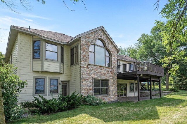 rear view of house featuring a lawn and a wooden deck