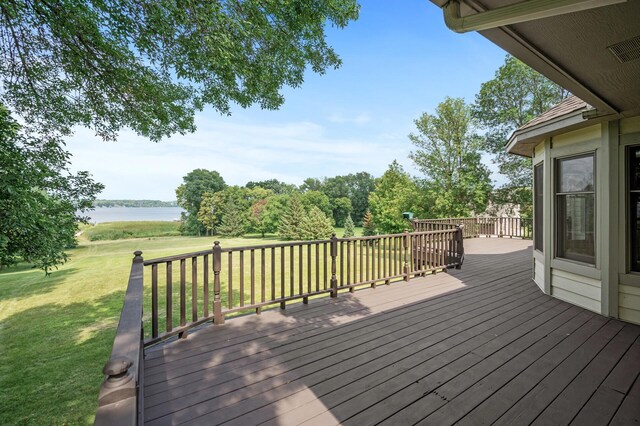 deck with a yard and a water view