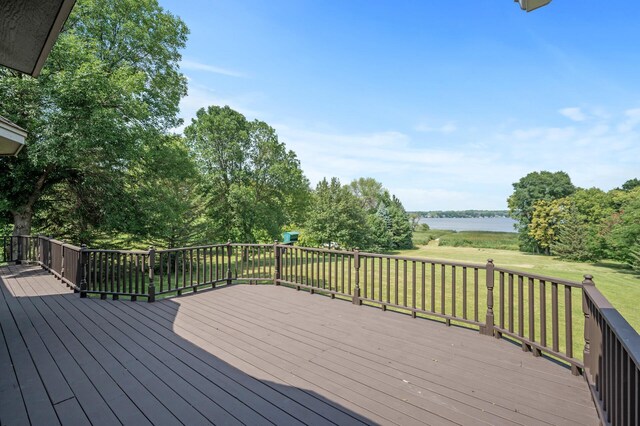 wooden deck featuring a lawn and a water view