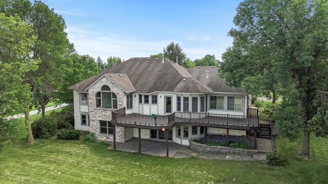 rear view of house with a patio area, a yard, and a wooden deck