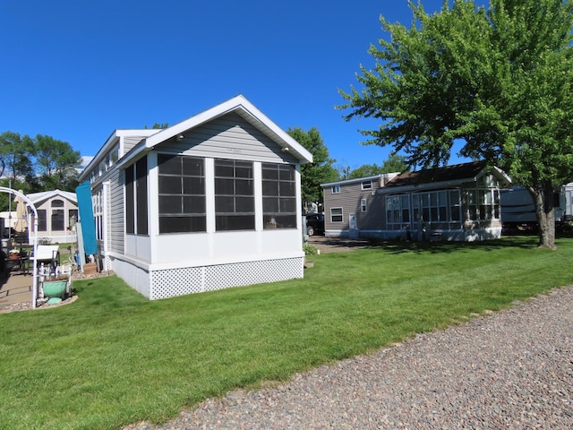 view of side of property with a sunroom and a yard