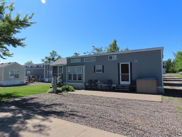 back of property featuring a patio area and a yard