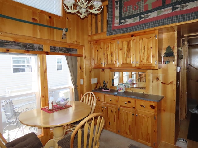 dining area with wooden walls and a notable chandelier