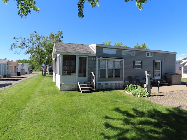 rear view of house with a sunroom and a yard