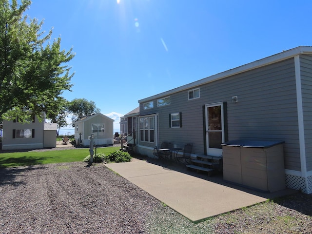 rear view of property with a patio and a lawn