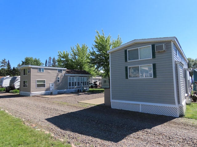 back of property featuring an AC wall unit