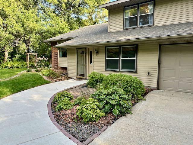 view of front of home featuring a garage and a shingled roof